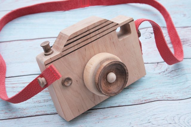 Drewniany aparat dla dzieci ze skórzanym paskiem